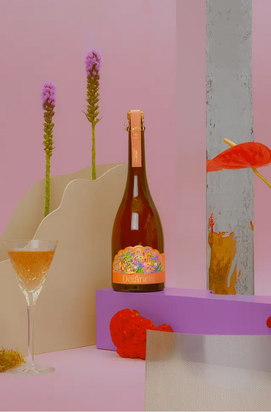 Delância rosé botanical sparkling wine bottle featured in an artistic, colourful studio lifestyle display